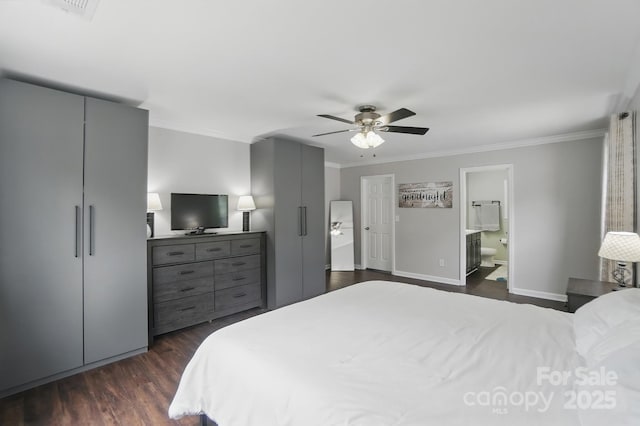 bedroom featuring ensuite bath, baseboards, dark wood-type flooring, and crown molding