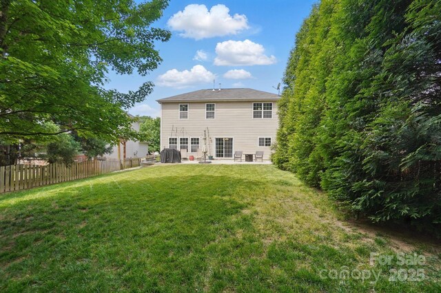 back of property with a lawn, fence, and a patio area