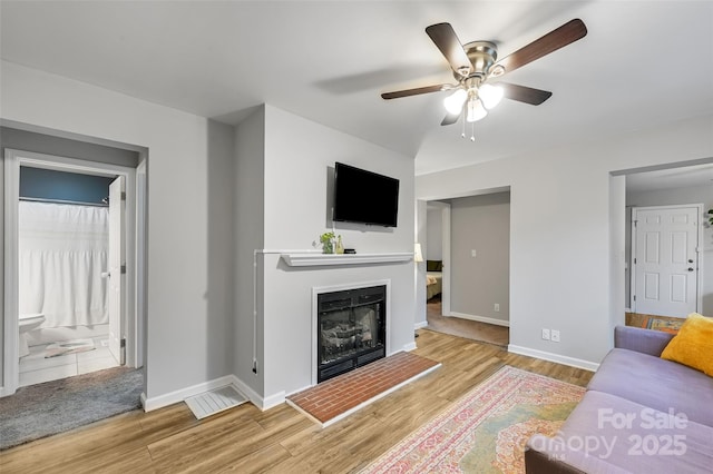 212 Short Michigan Ave, Asheville, NC 28806 - living area with a fireplace with raised hearth, baseboards, a ceiling fan, and wood finished floors