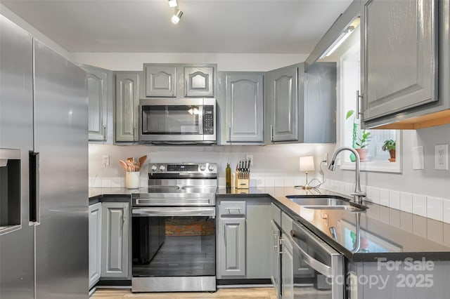 212 Short Michigan Ave, Asheville, NC 28806 - kitchen with gray cabinetry, dark countertops, a sink, and appliances with stainless steel finishes