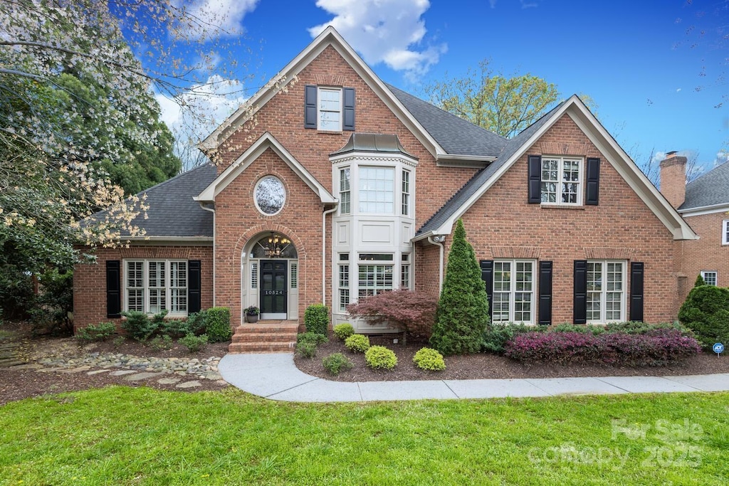 10524 Hadleigh Pl, Charlotte, NC 28210 - view of front of home with a front yard, brick siding, and a shingled roof