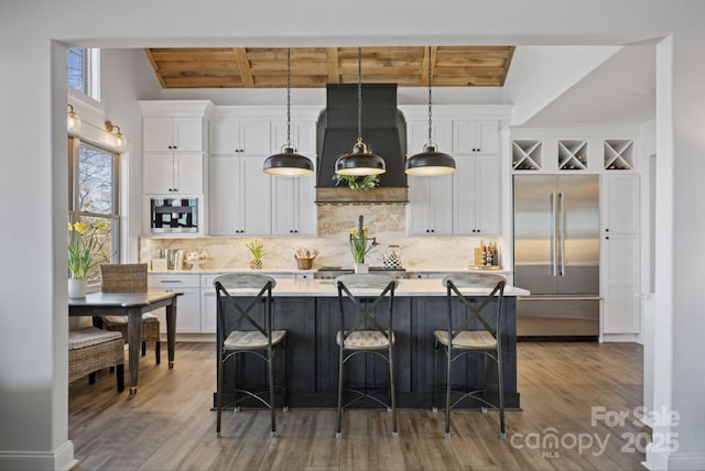 5888 Wood Duck Way, Catawba, NC 28609 - kitchen with built in refrigerator, wood finished floors, white cabinetry, light countertops, and a center island with sink