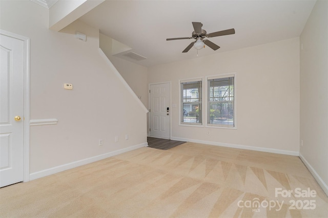 interior space featuring visible vents, baseboards, ceiling fan, carpet, and stairs