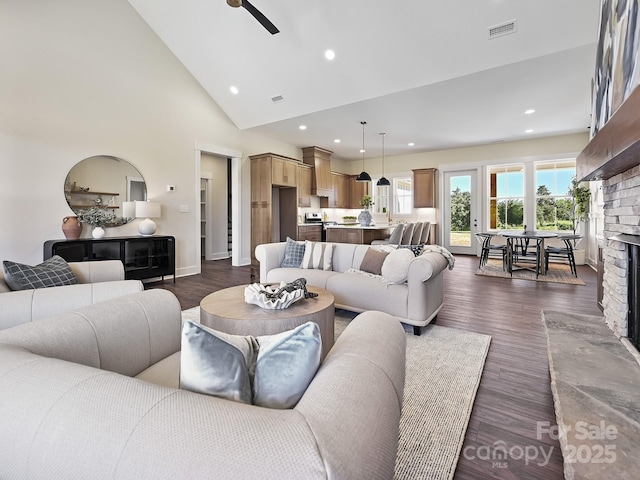 living room featuring a fireplace, dark wood finished floors, visible vents, and recessed lighting
