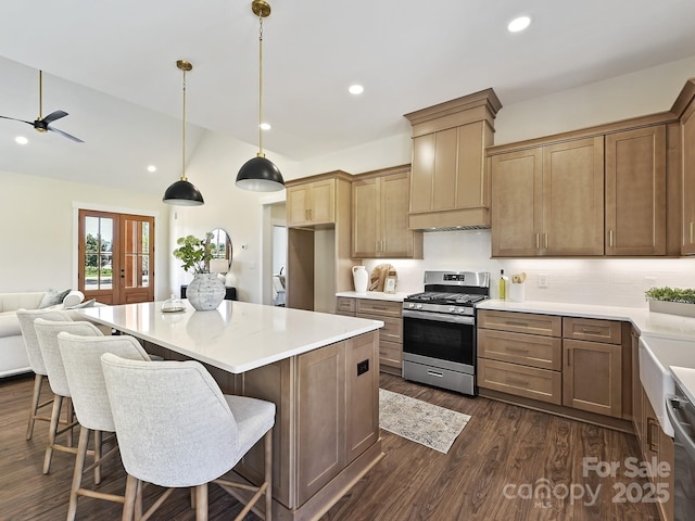 kitchen with stainless steel appliances, a center island, dark wood finished floors, open floor plan, and ceiling fan