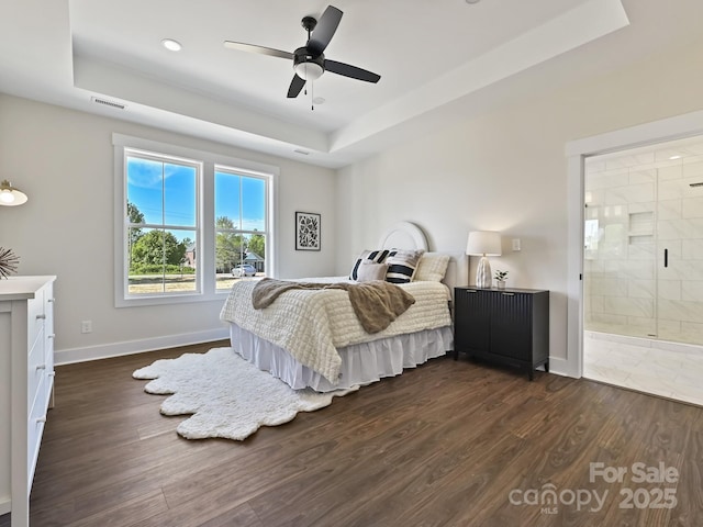 bedroom featuring baseboards, dark wood-style flooring, visible vents, and a raised ceiling