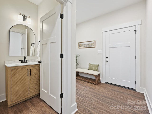bathroom featuring baseboards, wood finished floors, and vanity