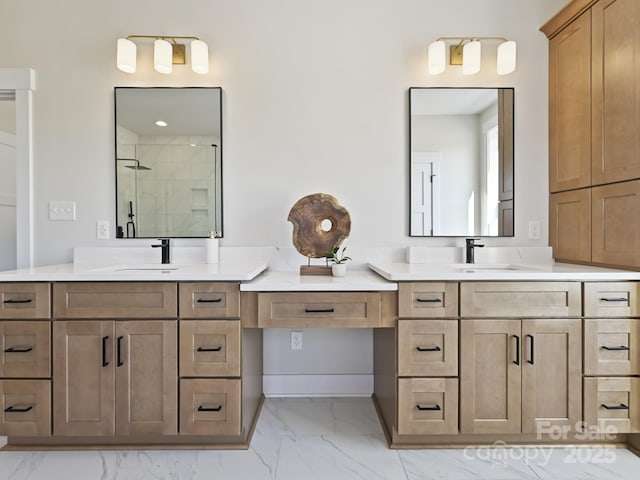 bathroom with marble finish floor, a sink, and a stall shower