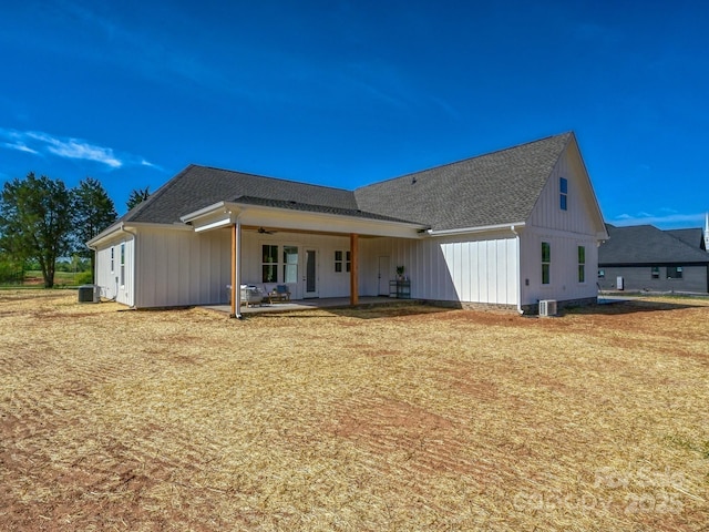 rear view of house featuring a ceiling fan, a shingled roof, cooling unit, board and batten siding, and a patio area