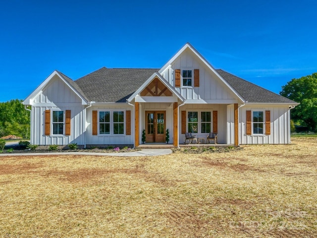 modern farmhouse featuring board and batten siding, a shingled roof, and covered porch
