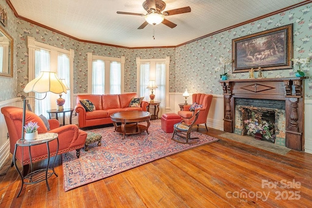 living area with hardwood / wood-style floors, wallpapered walls, and ornamental molding