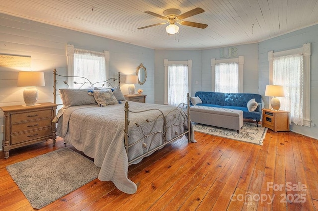 bedroom with ceiling fan, hardwood / wood-style flooring, and multiple windows