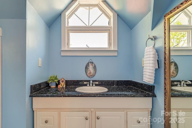 bathroom featuring lofted ceiling and vanity