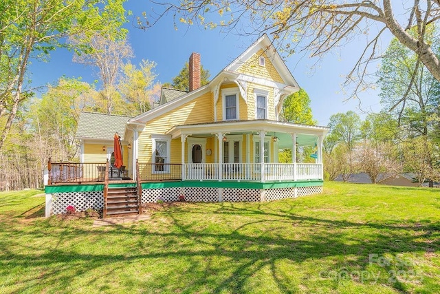 rear view of property featuring a lawn, stairway, and a chimney