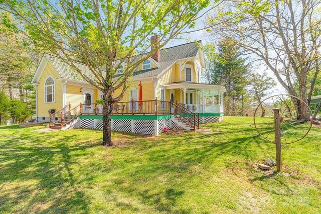 back of house with a chimney, stairway, and a yard
