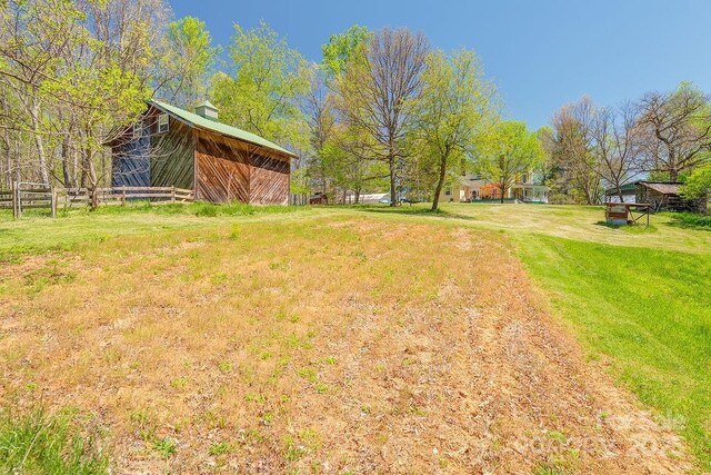 view of yard with fence and an outdoor structure