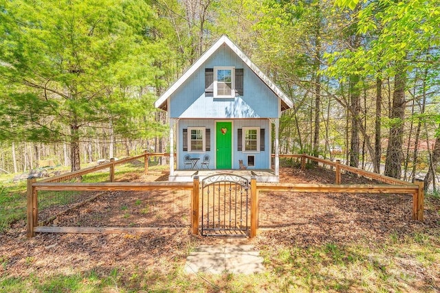 view of outbuilding featuring an outdoor structure, fence private yard, and a gate