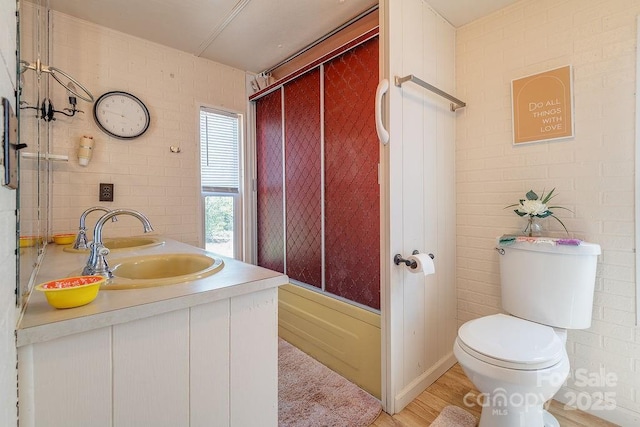 bathroom featuring toilet, enclosed tub / shower combo, and vanity