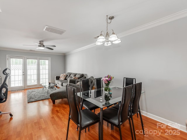 dining room featuring visible vents, ornamental molding, and wood finished floors