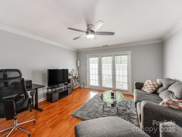 living room featuring light wood-style floors, ceiling fan, crown molding, and baseboards