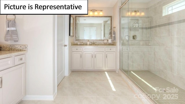 bathroom with tile patterned flooring, vanity, baseboards, and a stall shower