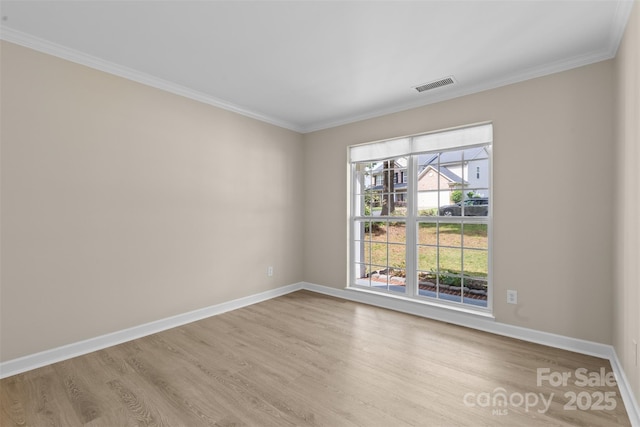 unfurnished room with visible vents, baseboards, crown molding, and wood finished floors