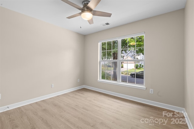 empty room with visible vents, light wood-style flooring, ceiling fan, and baseboards