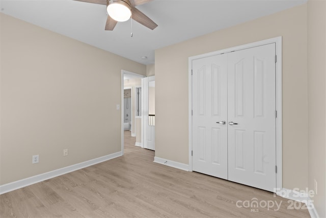 unfurnished bedroom with baseboards, a ceiling fan, light wood finished floors, and a closet