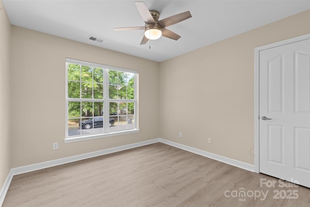 unfurnished bedroom featuring light wood-style floors, baseboards, a ceiling fan, and visible vents