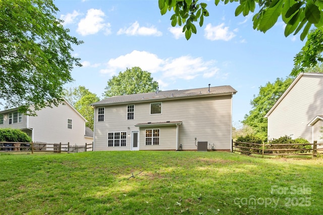 rear view of property featuring a lawn, a fenced backyard, and cooling unit