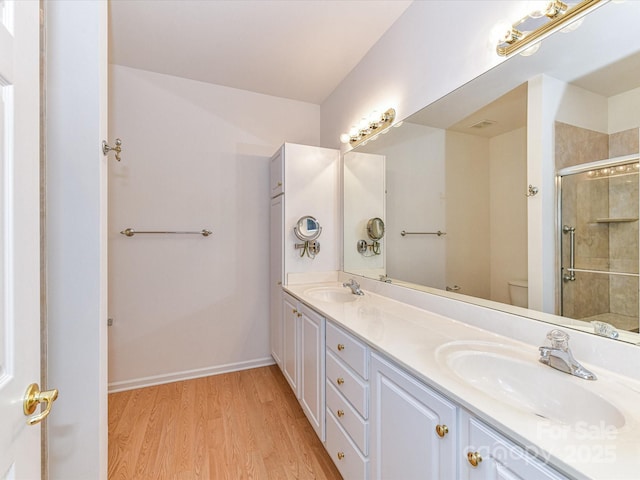 11705 Silverado Ln, Charlotte, NC 28277 - bathroom featuring wood finished floors, double vanity, tiled shower, toilet, and baseboards