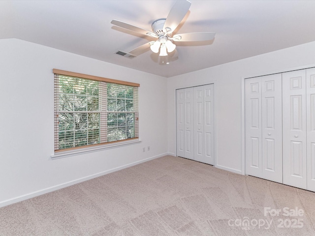 11705 Silverado Ln, Charlotte, NC 28277 - unfurnished bedroom with two closets, light carpet, baseboards, and ceiling fan