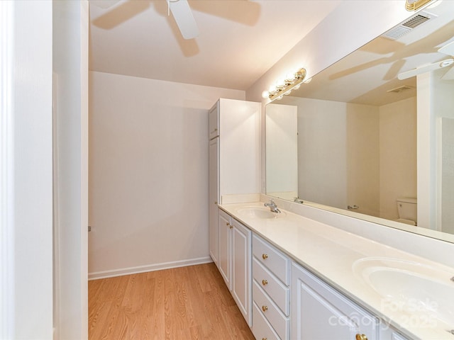 11705 Silverado Ln, Charlotte, NC 28277 - bathroom featuring a ceiling fan, double vanity, wood finished floors, toilet, and baseboards