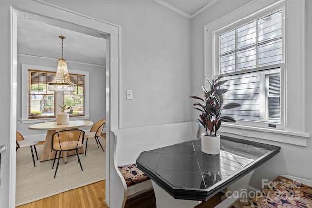 interior space featuring a notable chandelier, baseboards, crown molding, and wood finished floors