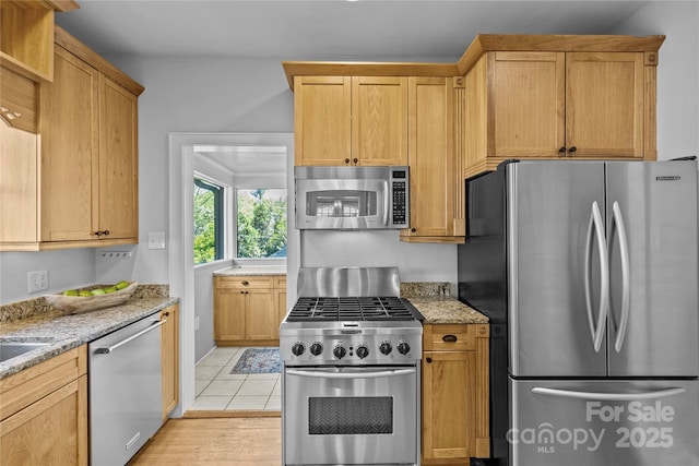 kitchen with appliances with stainless steel finishes and light stone counters