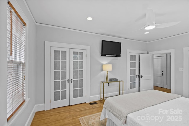 bedroom featuring crown molding, visible vents, wood finished floors, french doors, and baseboards