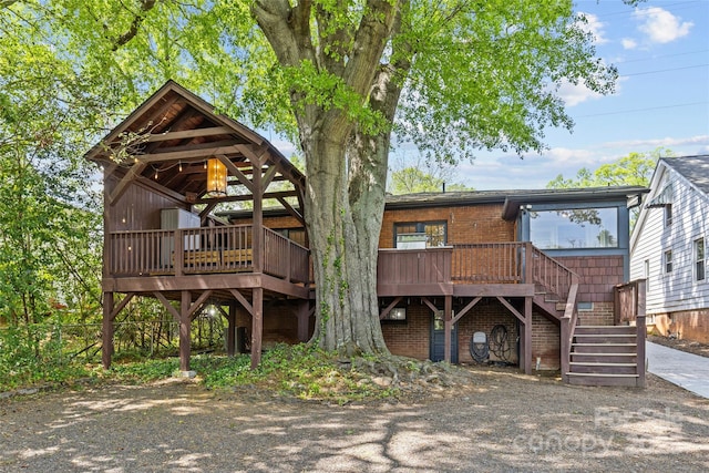 back of house featuring a deck and stairs