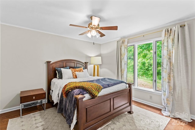bedroom featuring baseboards, light wood-style flooring, and multiple windows
