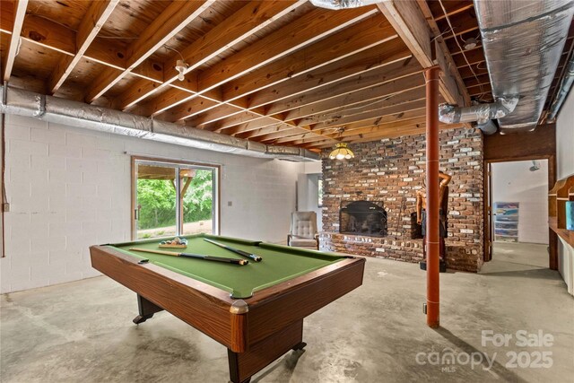 rec room with a fireplace, billiards, and concrete flooring