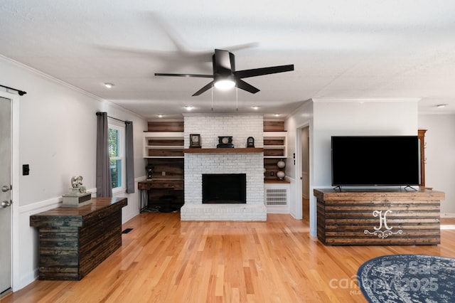1218 Donna Dr, Shelby, NC 28152 - living room featuring a fireplace, light wood finished floors, a ceiling fan, and ornamental molding