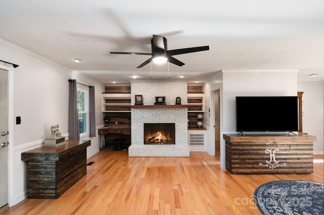 1218 Donna Dr, Shelby, NC 28152 - living area with light wood-style floors, ceiling fan, ornamental molding, a brick fireplace, and built in shelves