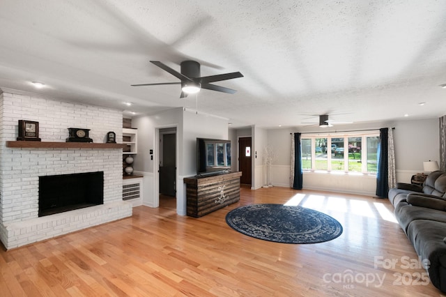 1218 Donna Dr, Shelby, NC 28152 - living area with light wood-style flooring, a textured ceiling, a ceiling fan, and a brick fireplace