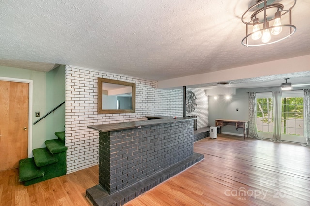1218 Donna Dr, Shelby, NC 28152 - bar with a textured ceiling, wood finished floors, brick wall, and stairs