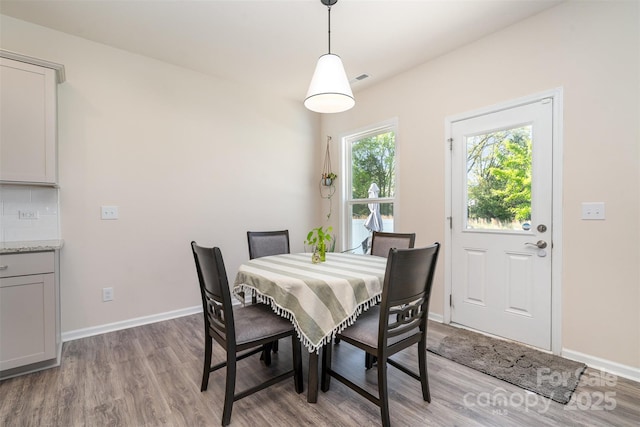 dining room with visible vents, baseboards, and light wood-type flooring
