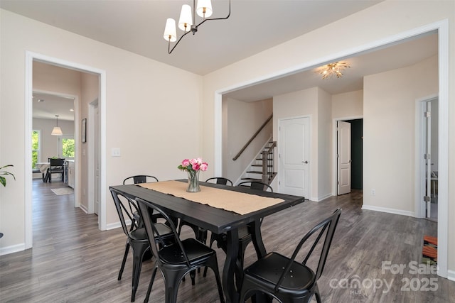 dining space featuring a chandelier, stairs, and dark wood-type flooring