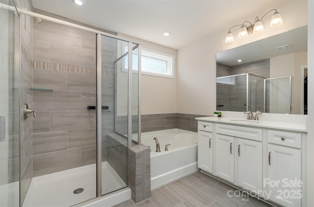 full bathroom featuring visible vents, a shower stall, vanity, and a garden tub