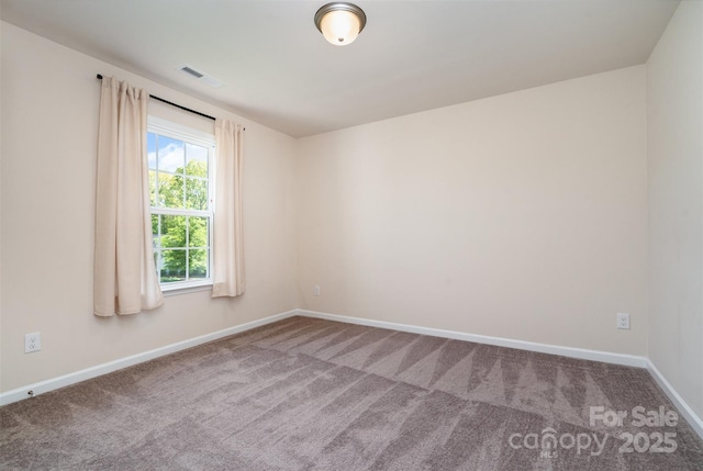 carpeted spare room with visible vents and baseboards