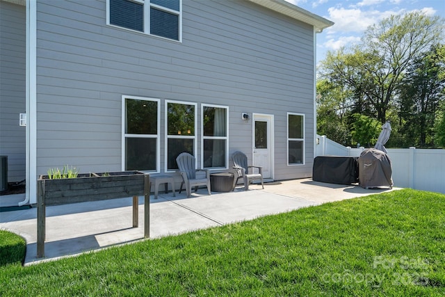 rear view of house with a patio area, a garden, a yard, and fence