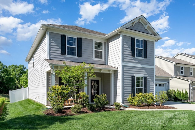 traditional home with a garage, driveway, fence, and a front lawn