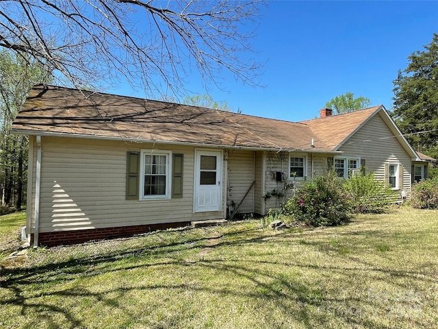 rear view of property with a lawn and a chimney